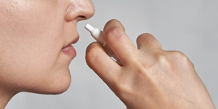 MHRA safety review. Woman using nasal spray. Photo by Marco Verch. Flickr.
