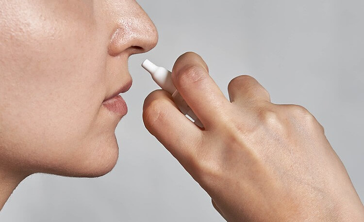 MHRA safety review. Woman using nasal spray. Photo by Marco Verch. Flickr.