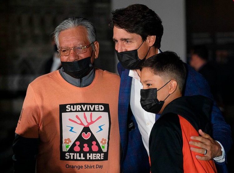Survivor and family with Prime Minister Trudeau. Photo by Beauty False. Flickr.