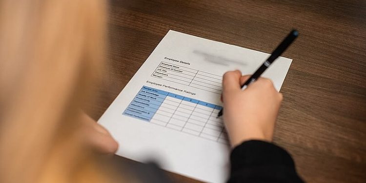 A woman filling in a claim form. Photo by Digits. Wikimedia.