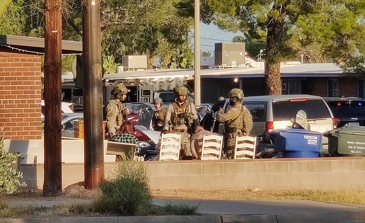 Arrested suspects seated outside the house. Photo by Ivan Golden. THX News.