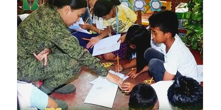 Woman soldier facilitates a session with children affected by recent NPA attacks in Masbate. Psychosocial first aid. Philippine News Agency.