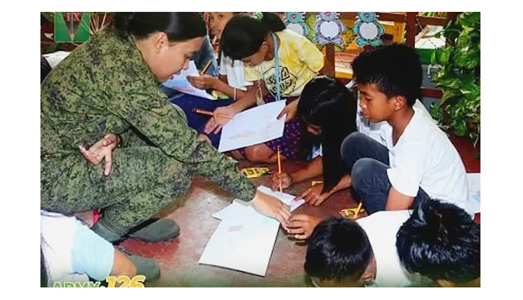 Woman soldier facilitates a session with children affected by recent NPA attacks in Masbate. Psychosocial first aid. Philippine News Agency.