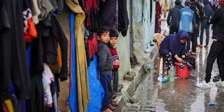 Children stand in front of the tent where they are staying with their families in Rafah, the Gaza Strip. Photo by El Baba. UNICEF.