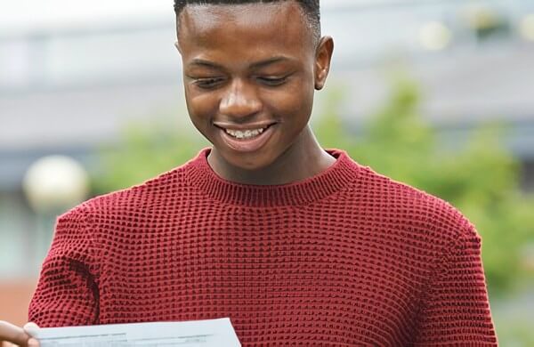 Teen with his A' level exam results. Photo by Department for Education. Gov.uk.