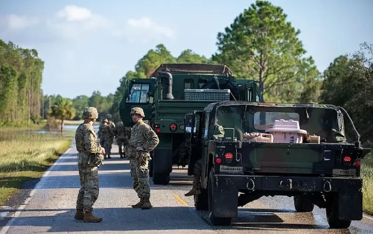 Soldiers clear road debris while assisting law enforcement at a checkpoint as part of their route clearing patrol in response to Hurricane Helene in Cedar Key, Fl. Photo by Army LT. Miles.