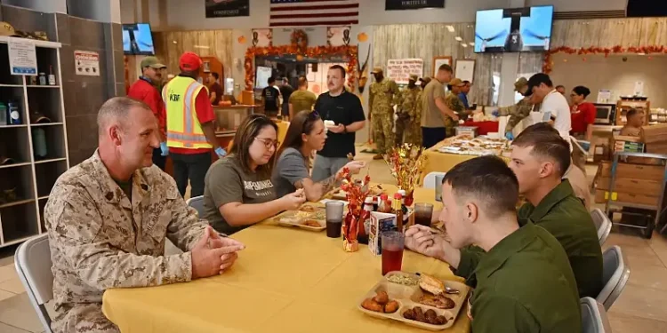 Marine Corps Sgt. Maj. Michael Woods, command senior enlisted leader, U.S. Africa Command, joins a table of deployed service members. Thanksgiving meals for troops. Photo by Master Sgt Quintanilla.