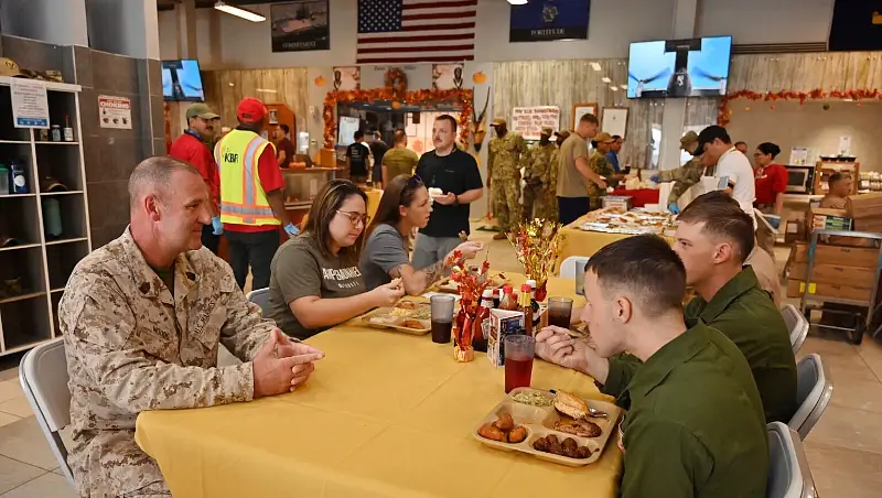 Marine Corps Sgt. Maj. Michael Woods, command senior enlisted leader, U.S. Africa Command, joins a table of deployed service members. Thanksgiving meals for troops. Photo by Master Sgt Quintanilla.