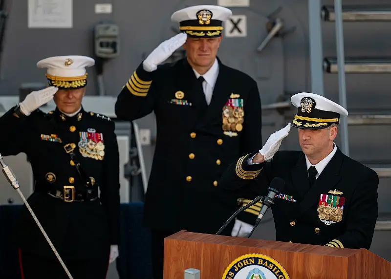 Navy Cmdr. Matthew S. Brooks, right, salutes during the playing of the national anthem during the USS John Basilone's commissioning ceremony on Pier 88 in New York, Nov. 9, 2024. Photo by NPO Mothershed.