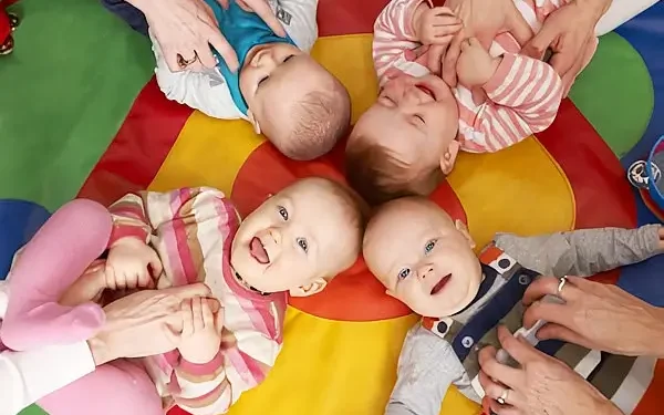 Babies giggling on a play mat. Photo by the Department for Education.