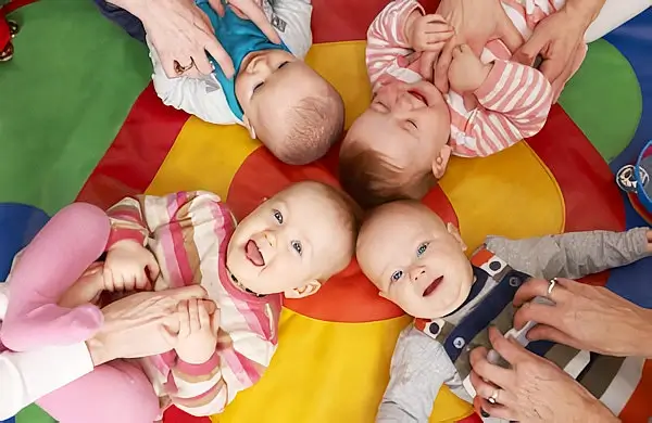 Babies giggling on a play mat. Photo by the Department for Education.