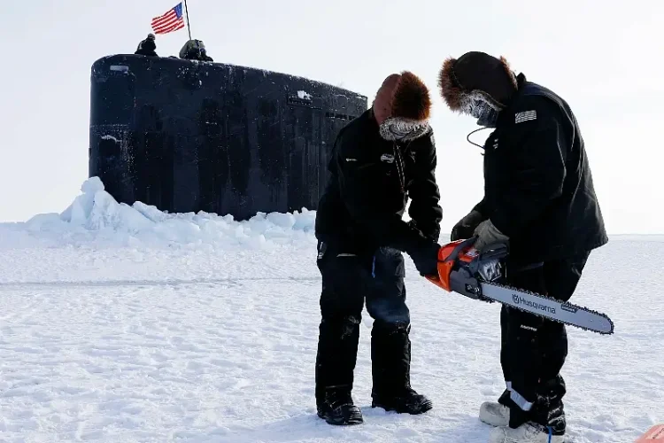 Field technicians with the Arctic Submarine Laboratory prepare to remove ice from the Los Angeles-class attack submarine USS Hampton at Ice Camp Whale. Photo by NPO Yarborough.