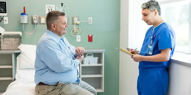 Male patient talking to the nurse. Photo by Getty Images.