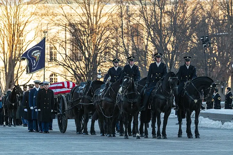 A ceremonial Honor Guard Joint Service Casket Team leads former President Jimmy Carter on a caisson during the procession service at the U.S. Navy Memorial Plaza in D.C.. Photo by Villarama.