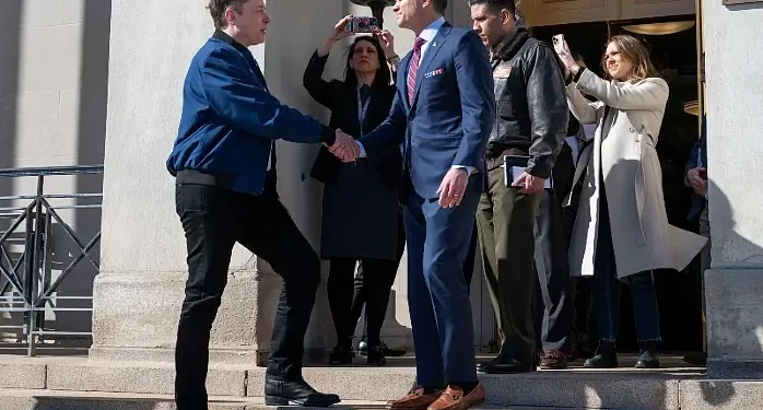 Defense Secretary Pete Hegseth shakes hands with Elon Musk as he exits the Pentagon, March 21, 2025. Photo by M. Keech.