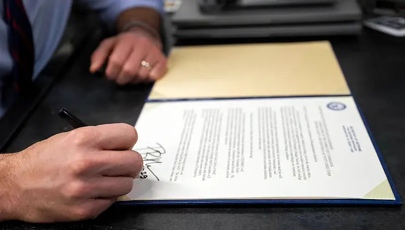 Defense Secretary Pete Hegseth signs a memorandum aboard an E-4B Nightwatch aircraft while flying over the Pacific Ocean. Photo by Air Force M. Keech.