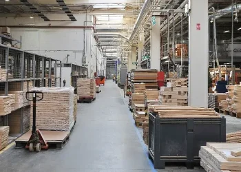 A corridor inside the ercol factory showing pallets of wood. Photo by Ercol.