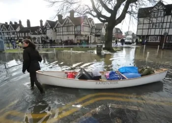 Interconnected risks of flooding - woman with canoe in a town center. Photo by Environment Agency.