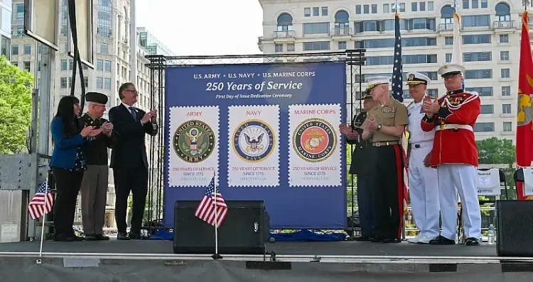 Service members and U.S. Postal Service employees applaud the unveiling of 3 new USPS commemorative stamps honoring the 250th anniversaries of the Army, Navy and Marine Corps. Photo by Nina Cortez.