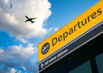 Departures sign with plane overhead. Photo by the Department for Transport.