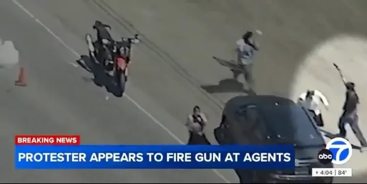 Protester firing a gun near Agents. Photo by ABC7 and ICE.