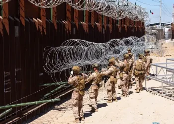 Marines assigned to Joint Task Force Southern Border place concertina wire on prefabricated brackets to reinforce the border barrier in Yuma, Ariz., July 29, 2025. Photo by Sgt Torres.