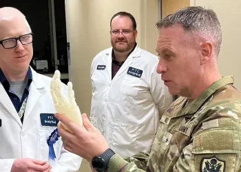 The Defense Logistics Agency Product Test Center Analytical employees Edward Dalton, engineer, and Mike McClain, artificial hand model concept to Army Brig. Gen. Sean P. Kelly. Photo by Mathews II.