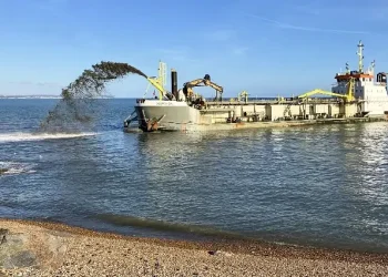 Shingle sprayed by the Sospan Dau will naturally settle into the right places through tidal action. Photo by the Environment Agency.