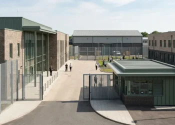 AI-generated photograph-style image of a secure UK prison and rehabilitation complex with staff and supervised residents.