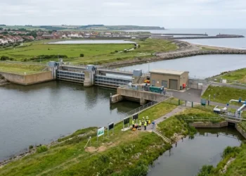 AI-generated photograph-style image of UK flood-control and coastal water infrastructure with engineers inspecting the site.