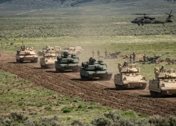 AI-generated photograph-style image of US Army soldiers, armored vehicles, artillery and a helicopter during a field exercise.