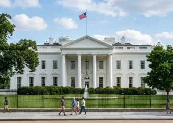 Illustrative view of the White House behind its gardens and perimeter fence in Washington, DC.